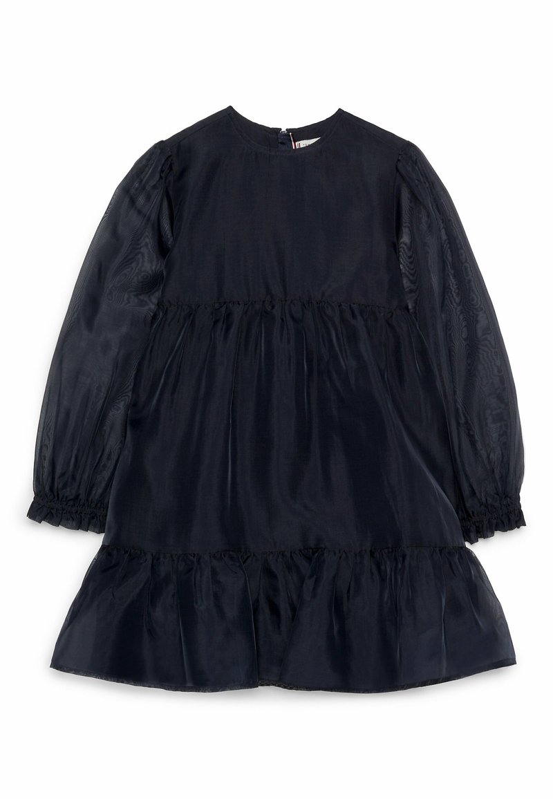 Tmavě modré šaty s dlouhými průsvitnými rukávy, nařaseným pasem a volánovou sukní. Hladká tkanina s jemným leskem a kulatým výstřihem.