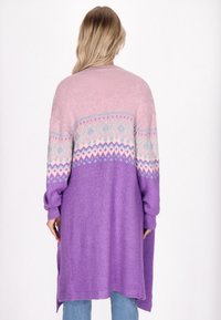 Lång cardigan i rosa och lila stickad tyg. Har en färgblockeringsdesign med ett geometriskt mönster på oket och lösa ärmar.