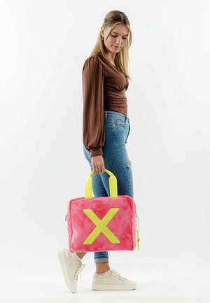 Borsa plush rosa con un grande design giallo a "X", manici gialli e una cerniera. Forma rettangolare con una consistenza morbida.