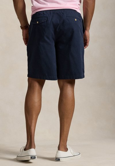 Tmavomodré šortky z jemnej, ľahkej látky s elastickým pásom a nenápadnými zadnými vreckami s kovovými doplnkami v zlatej farbe.