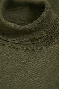 Olive zelena pulover z visokim ovratnikom, rebraste teksture, oprijeta izvedba, z visokim ovratnikom in subtilnimi šivi. Mehka, pletena tkanina.