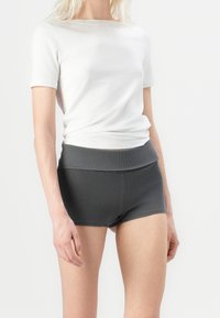 Witte katoenen t-shirt met korte mouwen, gecombineerd met ribbelgrijze hooggesneden shorts. Eenvoudig ontwerp met een getailleerde pasvorm.