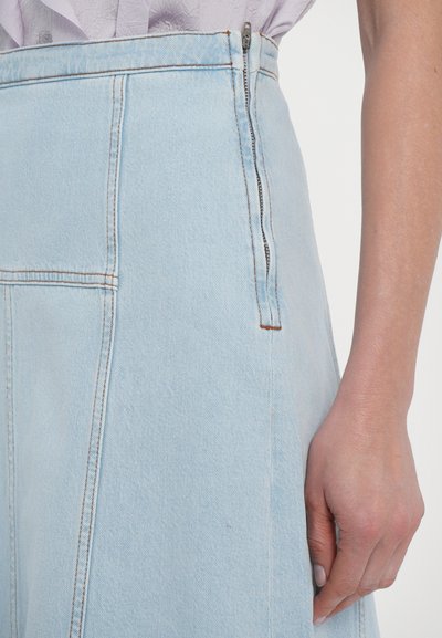 Light blue denim skirt featuring a high waist, visible stitching, a side zipper, and structured panels for a tailored fit.