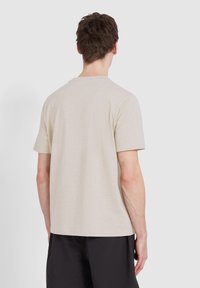 Beige T-Shirt mit kurzen Ärmeln und Rundhalsausschnitt, aus weicher Baumwolle, mit einem lockeren Schnitt und einem klaren, schlichten Design.