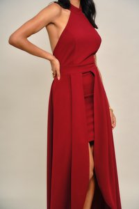 Raudona su kaklu surišama suknelė su figūrą išryškinančia viršutine dalimi ir laisvai krentančia suknele su šonine iškirpte. Švelnios tekstūros glotni medžiaga ir elegantiškas dizainas.