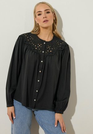 Sort bluse med en dekorativ broderet yoke, lange ærmer og knaplukning foran. Glat stof og afslappet pasform.