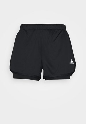 Pantalones cortos deportivos negros de Adidas con diseño de doble capa y logo blanco en la pierna inferior derecha, mostrados sobre un fondo liso.