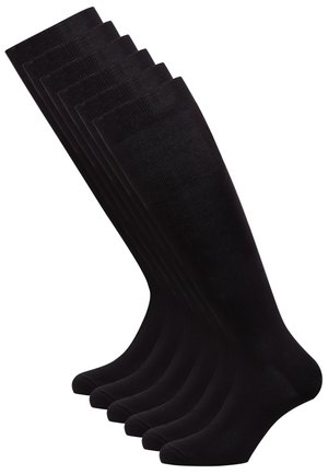 Calze nere fino al ginocchio, con una texture liscia, un design a costine nella parte superiore e una forma aderente. Sei paia disposti in fila.