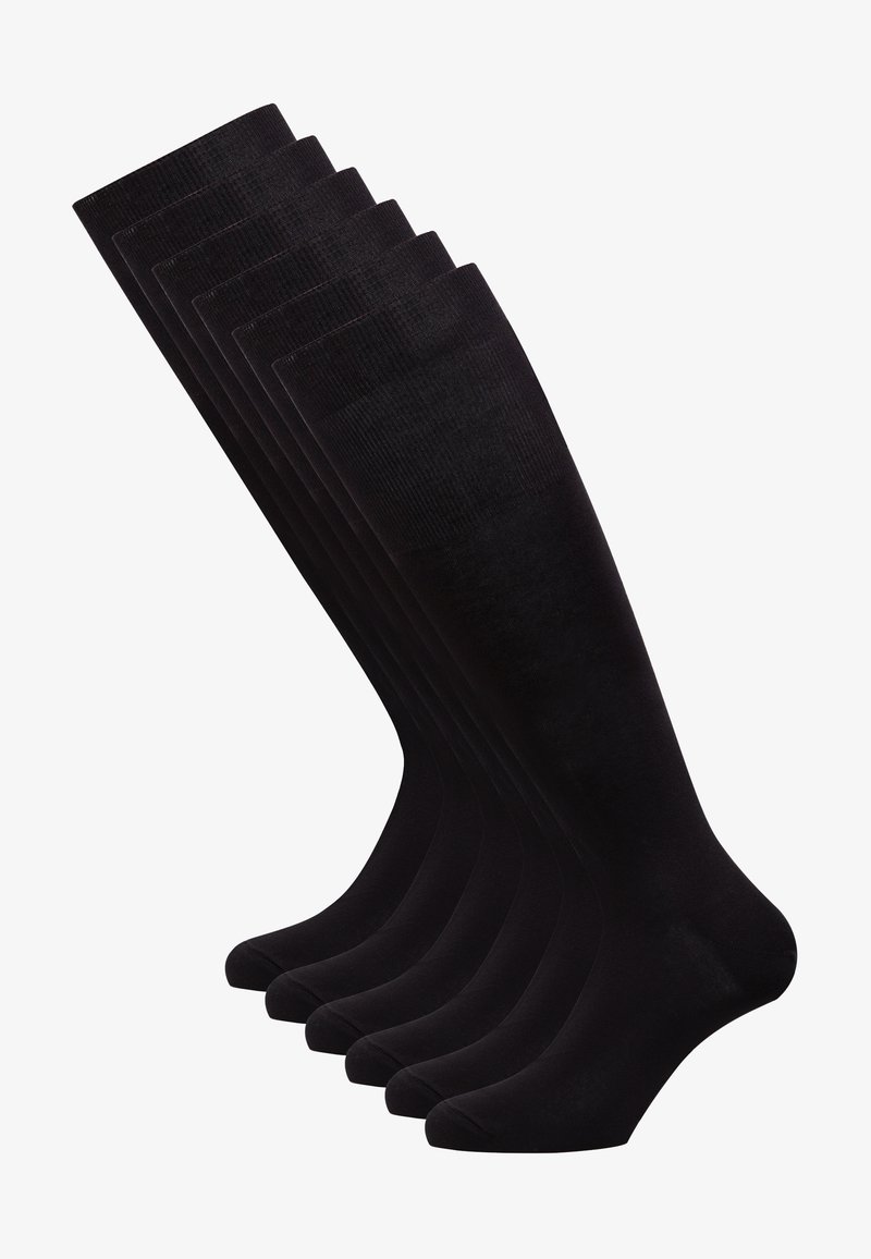 Calze nere fino al ginocchio, con una texture liscia, un design a costine nella parte superiore e una forma aderente. Sei paia disposti in fila.