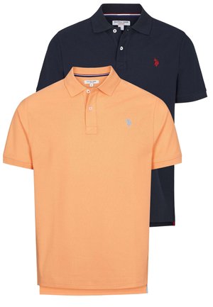 Dve polokošele: jedna oranžová s svetlomodrým logom a jedna námornícka modrá so červeným logom. Obe majú golier a krátke rukávy.
