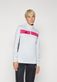 Long-sleeve athletic top in light blue, featuring a pink horizontal stripe and black accents. Made from smooth, breathable fabric.