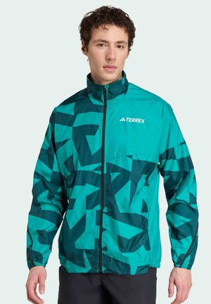 Turquoise and dark green patterned lightweight jacket with a zip closure, stand collar, and the "TERREX" logo. Features elastic cuffs.