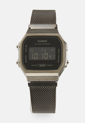Digital Casio watch with a rectangular black display, silver metal casing, mesh stainless steel band, features alarm and water resistance.