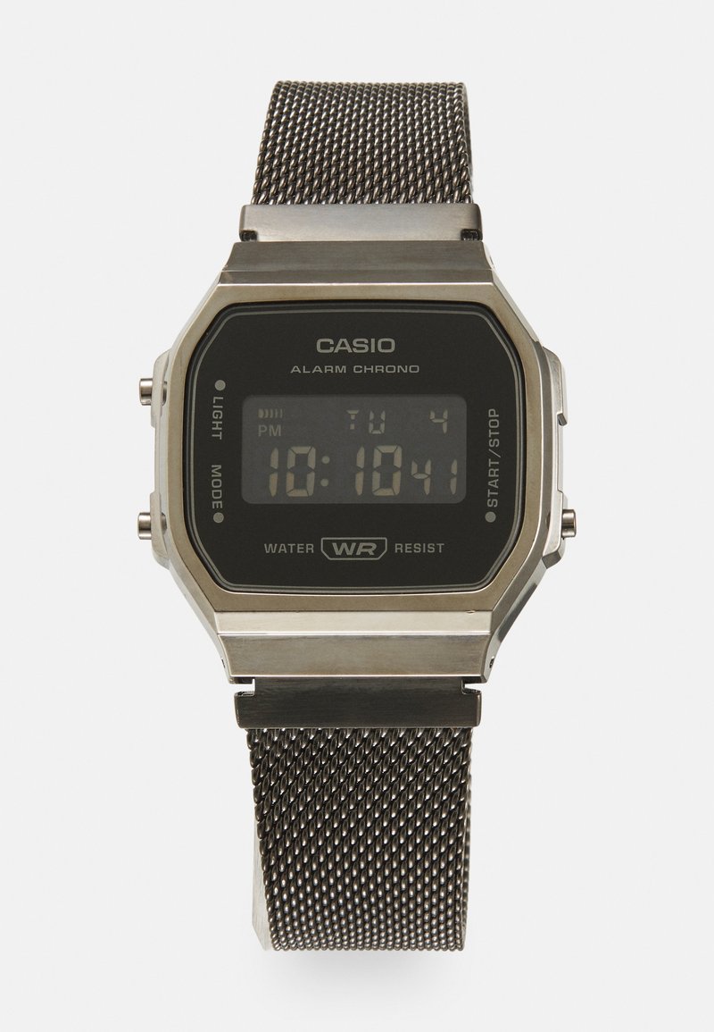 Montre numérique Casio avec un écran rectangulaire noir, boîtier en métal argenté, bracelet en acier inoxydable en maille, dotée d'une alarme et d'une résistance à l'eau.
