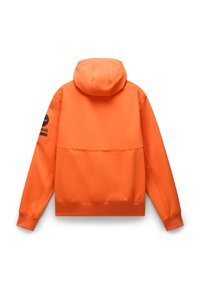 Giacca con cappuccio arancione dal tocco liscio, con bordo e polsini a coste. Presenta una toppa sulla manica sinistra e un design semplice ed elegante.