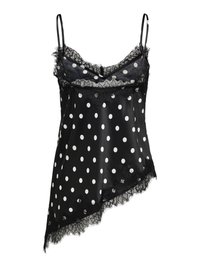 Camisole en satin noir à pois blancs, bordure en dentelle au niveau de l'encolure et de l'ourlet, coupe asymétrique et fines bretelles.