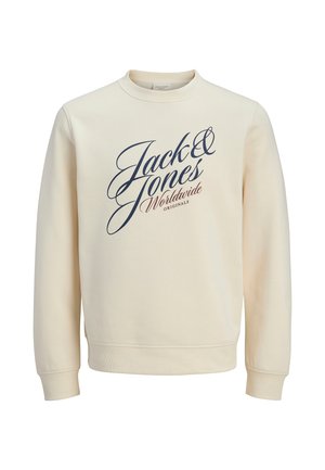 Sudadera de color crema con cuello redondo, mangas largas y puños acanalados. Presenta un logo en escritura azul marino en el frente. Textura suave.