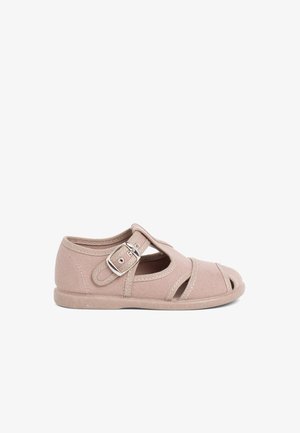 scarpa in tela beige con punta chiusa, design con ritagli, cinturino regolabile con fibbia e suola in gomma. Costruzione leggera e traspirante.