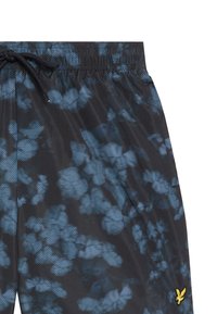 Costume da bagno a righe nere e blu con vita elasticizzata e cordino. Presenta un piccolo emblema giallo sul lato.