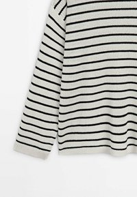 Pull en maille blanc avec de fines rayures horizontales noires et manches longues, présenté sur un fond blanc uni.