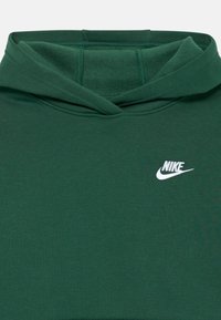 Πράσινη βαμβακερή hoodie με εμπρόσθια τσέπη kangaroo, ραμμένα μανίκια και λευκό λογότυπο Nike στο αριστερό στήθος. Λείο υφή, χαλαρή σχεδίαση.