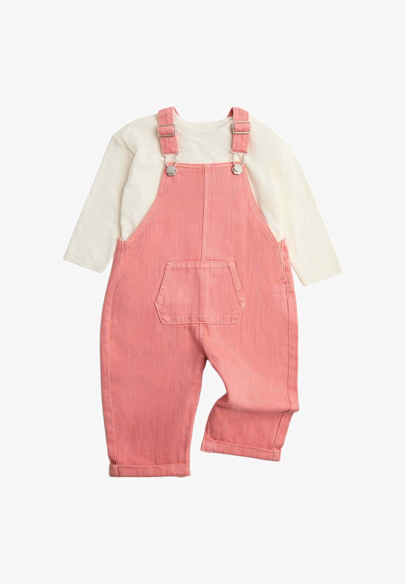 Camiseta de manga larga color crema combinada con un peto vaquero rosa con tirantes ajustables y un bolsillo delantero para ropa de niño pequeño.