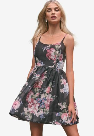 Black floral dress with spaghetti straps, featuring a fitted bodice, gathered skirt, and pink, blue, and green flower patterns.