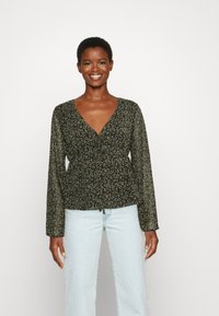 Blusa escura com padrões florais, mangas longas, decote em V, cintura franzida e tecido leve, apresentando pequenas flores roxas e verdes.