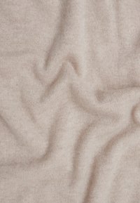 Tessuto a maglia rosa chiaro con una consistenza morbida, caratterizzato da una trama leggermente irregolare e onde delicate in tutto il tessuto.