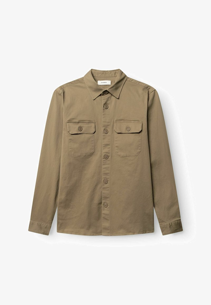 Chemise beige à manches longues pour hommes, à boutons, avec deux poches poitrine boutonnées et un col pointu, étalée à plat sur un fond blanc.