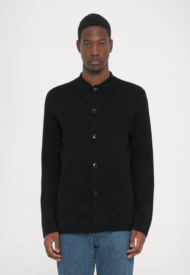 Zwarte wolmix cardigan met een kraag, zes knopen aan de voorkant, twee voorzakken en lange mouwen. Textuurafwerking zonder patronen.