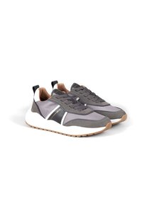 Scarpe atletiche grigie realizzate con un mix di materiali testurizzati. Presentano un accento bianco, lacci grigi e una suola in gomma leggera.