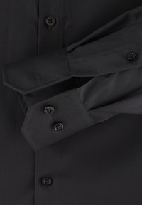 Schwarzes Hemd mit langen Ärmeln, spitzen Manschetten und zwei schwarzen Knöpfen an den Manschetten. Glatte Textur und einfarbig ohne Muster.