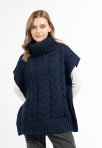 Marineblå strikket poncho med høj krave, med et kabelmønster og ribbet kant. Korte ærmer og løs pasform giver komfort.