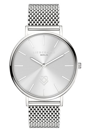 Silberne analoge Uhr mit minimalistischem rundem Ziffernblatt, Netzarmband und einfachen Stundenmarkierungen. Zeigt den Markennamen "LIEBESKIND" und ein einzigartiges Herz-Logo.