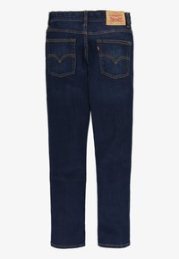 Jeans de mezclilla rectos de color azul oscuro con dos bolsillos traseros, costuras amarillas y un parche de cuero de la marca Levi Strauss & Co. en la cintura.