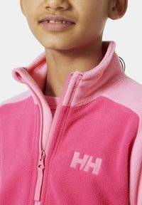 Różowa polarowa kurtka zapinana na zamek z kontrastującymi jasnoróżowymi akcentami. Posiada wysoki kołnierz, boczny zamek i haftowane logo "HH" z przodu.