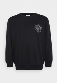 Sudadera negra de mangas largas, con un cuello redondo y un gráfico de sol en blanco en la parte izquierda del pecho. Textura de tela suave.