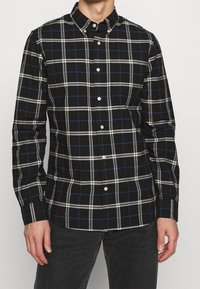 Zwart-wit geblokt overhemden met blauwe accenten, met een puntige kraag en lange mouwen, gemaakt van katoen.