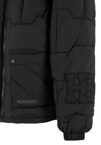 Juodas pūkinis švarkas su siuvinėjimu, šonine kišenę ir išsiuvinėtu "HOMEBOY" logotipu. Savybės: elastiniai rankogaliai ir užtrauktukas priekyje.