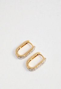 Zlatne pravokutne naušnice s redom malih prozirnih dragih kamenčića duž jedne strane, postavljene na bijelu pozadinu.