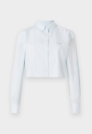 Lyseblå cropped button-up skjorte med lange ermer, med tynne striper og krage. Inkluderer liten brodert logo på brystet.