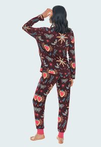 Conjunto de pijama burdeos con mangas largas y pantalones; presenta patrones coloridos de corazones, polillas y estrellas; puños de canalé rosa en los tobillos.