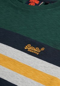 Grønne og marineblå stribede T-shirt med grå og gule striber, prydet med et broderet "SuperDry" logo i orange på brystet.