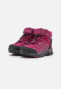 Magenta and black hiking boots with a high ankle design. Features a reinforced toe cap, adjustable straps, and textured rubber sole.
