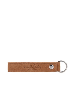 Brauner Wildleder-Schlüsselanhänger mit Metallring und Druckknopf, geprägt mit "Quali Leder studio" auf weißem Hintergrund.
