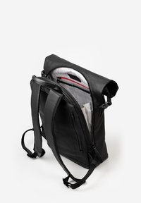 Schwarzer Leder-Rucksack mit verstellbaren Trägern, Rolltop-Verschluss und einer Reißverschlusstasche. Das Innere verfügt über ein Netzfutter und ein sicheres Reißverschlussfach.