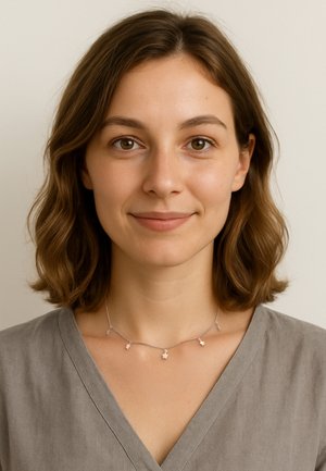 Sart sølv halskæde med fem stjernesformede pendanter, der har en fin kæde. Modellen bærer en grå v-hals top. Neutral baggrund.
