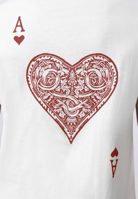 Σχεδιασμός τραπουλόχαρτου άσσος των καρδιών με περίπλοκα κόκκινα μοτίβα και θέματα φιδιού σε λευκό φόντο.