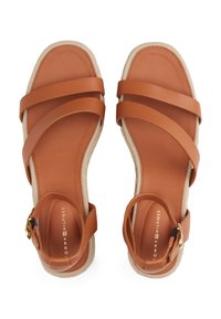 Brown leather sandals with wide straps, a textured beige midsole, and a buckle closure. Smooth finish and open toe design.